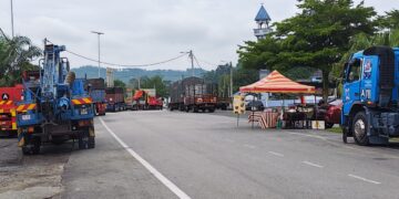 BARISAN kenderaan berat berbaris berdekatan sebuah gerai dan masjid di Jerantut Feri, Jerantut, Pahang untuk melakukan pemeriksaan kenderaan di bawah Jambatan Sungai Pahang.