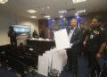 ZAKARIA Shaaban menujukkan hasil rampasan daripada sindiket scam dalam sidang akhbar di Putrajaya.