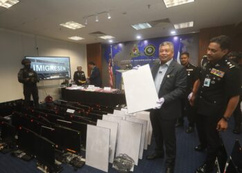 ZAKARIA Shaaban menujukkan hasil rampasan daripada sindiket scam dalam sidang akhbar di Putrajaya.
