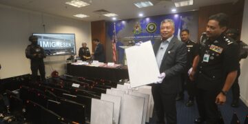 ZAKARIA Shaaban menujukkan hasil rampasan daripada sindiket scam dalam sidang akhbar di Putrajaya.
