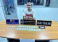 SUSPEK menunjukkan dadah yang dirampas selepas ditahan Polis Thailand dalam serbuan di Sungai Golok, Thailand malam tadi-IHSAN POLIS.