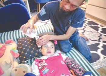 MEOR Mohd Zainudin 
memberi susu menggunakan tiup kepada  anaknya ketika ditemui 
di Taman Bernam Permai, Tanjung Malim, Perak. – UTUSAN/AIN SAFRE BIDIN
