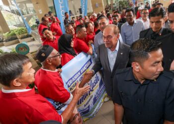 Anwar Ibrahim beramah mesra dengan penerima bantuan pemandu teksi di Putrajaya. - UTUSAN/FAISOL MUSTAFA