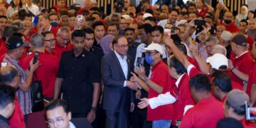 Anwar Ibrahim beramah mesra dengan penerima bantuan pemandu teksi di Putrajaya. - UTUSAN/FAISOL MUSTAFA
