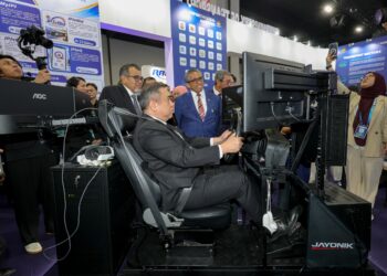 ANTHONY Loke (tengah) mencuba simulasi membawa kenderaan ketika melawat reruai pada Majlis Perasmian Ekspo Pengangkutan Asia (TXA) 2026 di Pusat Pameran dan Perdagangan Antarabangsa Malaysia (MITEC) di sini hari ini.