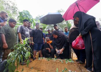 Mior Sharizal, 48 (tengah) dan isterinya, Derma Taksiah @ Norlela, 51 menabur bunga pada pusara anaknya, Derma Damiya Nur Mikayla, 7 di Tanah Perkuburan Islam Dengkil, di Putrajaya. - UTUSAN/ FAISOL MUSTAFA