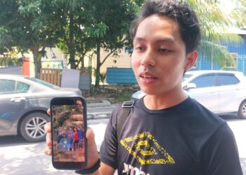 MUHAMMAD Aqil Yusri menunjukkan gambar kenangan ketika bercuti bersama rakan baiknya, Allahyarham Mohamad Nazhif Faris Mohd. Fauzi ketika ditemui di pekarangan Jabatan Forensik Hospital Pulau Pinang (HPP), hari ini.-UTUSAN/SAFINA RAMLI