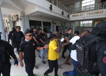 AHLI Geng Suria dikawal anggota polis ketika menghadapi pertuduhan menyertai kumpulan jenayah terancang di Mahkamah Sesyen Sungai Petani, hari ini.