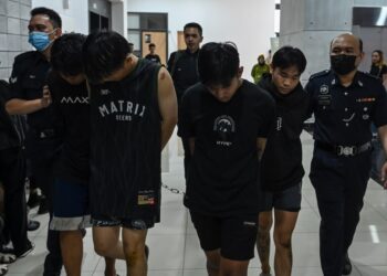 EMPAT individu yang terbabit dalam pergaduhan membabitkan dua kumpulan di sebuah tokong ketika dibawa anggota polis ke Mahkamah Ampang, di sini hari ini. - UTUSAN/SYAKIR RADIN