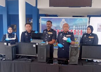 HANYAN Ramlan (dua kanan) menunjukkan barangan yang dirampas membabitkan kegiatan penipuan dalam talian setelah menyerbu sebuah hotel terbiar di Sungai Petani.