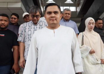 MUHAMAD Akmal Saleh (tengah) bersama ahli keluarga serta penyokongnya ketika tiba di pekarangan Kompleks Mahkamah Bukit Mertajam, Pulau Pinang untuk mendengar keputusan representasi susulan kenyataan kontroversinya berhubung isu Jalur Gemilang sebelum ini.-UTUSAN/DANIAL SAAD