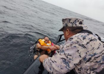 ANGGOTA Maritim Malaysia membantu seorang kru kapal korek pasir MV Vivo Arya yang tenggelam kira-kira 25 batu nautika barat laut Pulau Pasir Hitam, Perak, semalam. – IHSAN MARITIM MALAYSIA