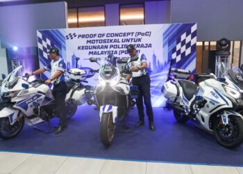 MUHAMMED Hasbullah Ali (kanan) melihat motosikal yang akan digunakan oleh anggota trafik pada majlis Proof of Concept (PoC) di ibu pejabat Mforce di Valdor, Nibong Tebal, Pulau Pinang.-UTUSAN/DANIAL SAAD