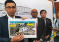 H'ng Mooi Lye (kiri) menunjukkan gambar terkini mengenai kawasan tanah runtuh di Taman Seri Rambai, Paya Terubong, George Town, Pulau Pinang.-UTUSAN/SAFINA RAMLI