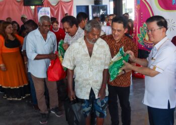 CHOW Kon Yeow (kanan) dan Goh Choon Aik (dua dari kanan) menyerahkan bantuan beras dan barang keperluan lain kepada penduduk setempat sempena program Deepavali Madani & Kesejahteraan Pengguna 2026 di Taman Merak, Simpang Ampat, Pulau Pinang.-UTUSAN/DANIAL SAAD