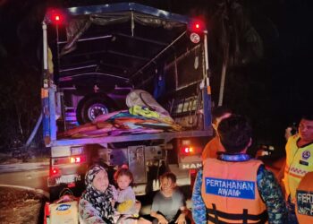 ANGGOTA Angkatan Pertahanan Awam Malaysia (APM) memindahkan mangsa banjir di Batu 7 Changkat Jering di Taiping semalam. - UTUSAN/APM