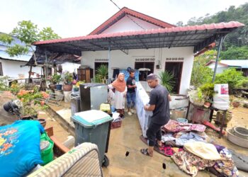 PENDUDUK membersihkan peralatan rumah yang terkena banjir di Pulau Pangkor hari ini. - UTUSAN/AIN SAFRE BIDIN