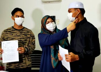 NOR Azwani Ahamad menunjukkan kesan kecederaan yang dialami anaknya yang didakwa dibuli di sebuah sekolah menengah agama  di Chemor dalam sidang akhbar di Tanjung Rambutan, Ipoh hari ini.