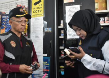 GHAZALI Chik (kiri) membuat pemeriksaan di salah sebuah premis semasa Operasi Bersepadu Penguatkuasa Kesihatan Awam Mega di sekitar Jalan Sarawak, Kuala Perlis, Perlis, hari ini. -UTUSAN/ASYRAF MUHAMMAD