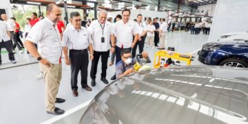 KETUA Pegawai Operasi Kumpulan DRB Hicom, Datuk Jezilee Mohamad Ramli (dua dari kiri) dan Akkbar Danial (paling kiri), melawat ruang kerja pada Majlis Pelancaran Pusat Baik Pulih Badan dan Cat EON di Kawasan Perindustrian Temasya, Glenmarie di sini semalam. UTUSAN/SHIDDIEQIIN ZON