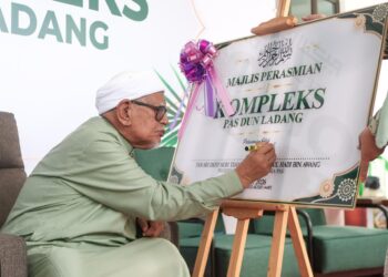 ABDUL Hadi Awang menandatangani plak sebagai gimik merasmikan Kompleks Pas DUNLadang, Kuala Terengganu, Terengganu. - UTUSAN/PUQTRA HAIRRY