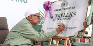 ABDUL Hadi Awang menandatangani plak sebagai gimik merasmikan Kompleks Pas DUNLadang, Kuala Terengganu, Terengganu. - UTUSAN/PUQTRA HAIRRY
