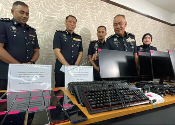 MOHD. Alwi Zainal Abidin (depan) menunjukkan barang yang dirampas selepas serbuan terhadap sindiket penipuan perjudian dalam talian di Kamunting, Taiping pada Selasa lalu dalam sidang akhbar di IPK Perak di Ipoh hari ini.