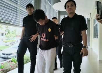 TERTUDUH semasa dibawa untuk prosiding pertuduhan di Mahkamah Seksyen Pasir Mas Kelantan. - UTUSAN/ROHANA ISMAIL