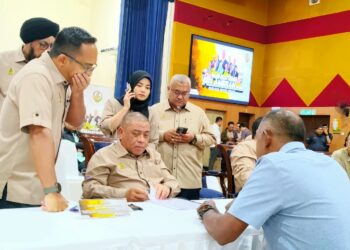 SAARANI Mohamad meneliti aduan rakyat pada Program Mesra Hari Bertemu Pelanggan di Tanjung Malim hari ini. - UTUSAN