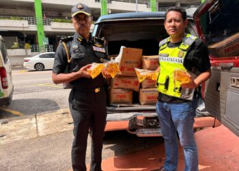 HANIF Yusabra Yusuf (kiri) menunjukkan minyak masak peket yang dipercayai mahu diseludup ke negara jiran di Kota Bharu, Kelantan. - UTUSAN / ROSLIZA MOHAMED