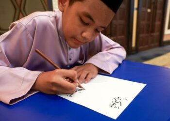 MUHAMMAD Al Amin Muhammad Adli menunjukkan kemahirannya menghasilkan tulisan khat semasa ditemui baru-baru ini dalam satu Festival Kaligrafi Islam Terengganu di Kuala Terengganu.