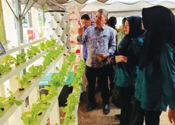Ir. Zulkernai Fauzi (tiga dari kanan) mendengar penerangan pelajar ketika melawat projek tanaman sorghum di Kolej Vokasional Chenor, Maran, Pahang baru-baru ini.
