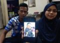SHARIFATUL Hapizah (kanan) bersama suaminya, Muhammad Zulkarnain Abdullah menunjukkan gambar Allahyarham Muhammad Faris yang maut selepas dipercayai dicederakan oleh pengasuh di Kampung Geting, Tumpat, Kelantan.