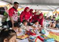 ALFIRZA Munira Abdul Muin (kanan) menyantuni peserta pertandingan mewarna pada Karnival Penjaja dan Usahawan Bersama Komuniti 2026 di Ipoh hari ini.