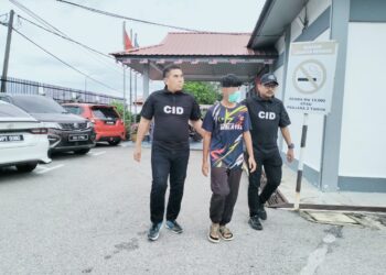 TERTUDUH dibawa polis untuk prosiding pertuduhan di Mahkamah Majistret, Machang, Kelantan. - UTUSAN/ROHANA ISMAIL