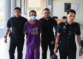 TERTUDUH (dua dari kiri) semasa dibawa oleh polis untuk prosiding pertuduhan di Mahkamah Majistret Pasir Mas, Kelantan. - UTUSAN/KAMARUL BISMI KAMARUZAMAN