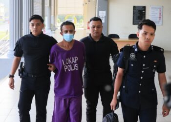 TERTUDUH (dua dari kiri) semasa dibawa oleh polis untuk prosiding pertuduhan di Mahkamah Majistret Pasir Mas, Kelantan. - UTUSAN/KAMARUL BISMI KAMARUZAMAN