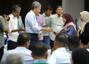 MOHAMAD Hasan menyampaikan sumbangan kepada penerima warga Parlimen Rembau di Dewan Orang Ramai Rantau, Negeri Sembilan, semalam. - UTUSAN/MOHD. SHAHJEHAN MAAMIN