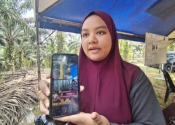 NUR Aliyah Zamin menunjukkan mesej menerusi aplikasi WhatsApp lokasi terakhir suaminya yang tersesat di di kawasan hutan berhampiran kawasan rekreasi La Hot Spring, Besut, Terengganu. - UTUSAN / WAN ZURATIKAH IFFAH WAN ZULKIFLI