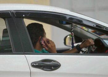 MENGGUNAKAN telefon bimbit semasa memandu merupakan satu kesalahan jalan raya-GAMBAR HIASAN