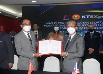 MUHAMMAD Sanusi Md. Nor (tengah) menyaksikan Ku Abd. Rahman Ku Ismail (depan, kanan) dan Affendi Mohamed Zain bertukar dokumen selepas menandatangani MoA bagi membangunkan hub e-dagang dan logistik di Alor Setar hari ini. - UTUSAN/MOHD. RAFIE AZIMI