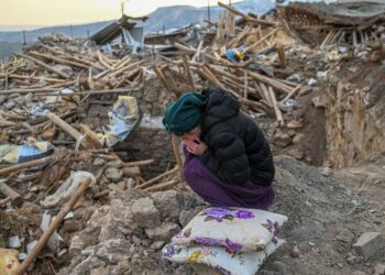 GAMBAR menunjukkan seorang wanita menangis ketika duduk di atas runtuhan rumahnya di kampung Yaylakonak di daerah Adıyaman. -AFP