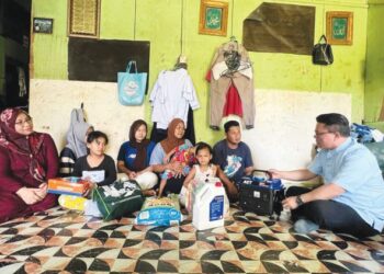MOHD. Azizi Abu Naim (kanan) menyampaikan set generator kepada keluarga Rusmawaty Rusdy di Kampung Baru, Gua Musang, Kelantan. - UTUSAN/AIMUNI TUAN LAH