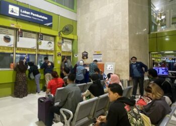 PENUMPANG kereta api sedang menunggu di kaunter pembatalan tiket di Stesen Gambir, Jakarta. - AGENSI 