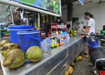 SEORANG penduduk
membeli kelapa di sebuah
gerai makanan di Jakarta,
Indonesia. – AGENSI