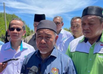 TUAN Ibrahim Tuan Man (kanan) diiringi Ghulam Haidar (kiri) semasa melawat kawasan banjir di Kampung Pengalat Besar, Papar hari ini.