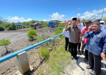 TUAN Ibrahim Tuan Man (kanan) diiringi Ghulam Haidar (kiri) semasa melawat kawasan banjir di Kampung Pengalat Besar, Papar hari ini.