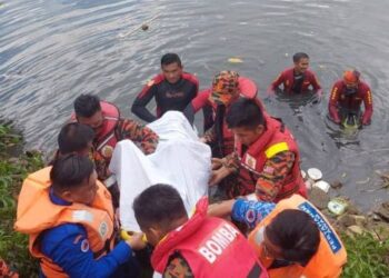 PASUKAN Bomba mengangkat mayat mangsa yang ditemukan lemas di Sungai Petagas, Putatan hari ini.
