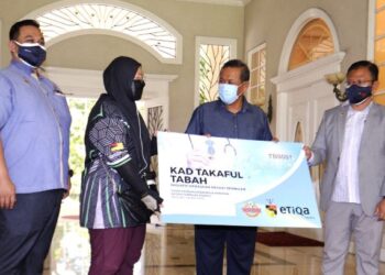AMINUDDIN Harun Menyampaikan Kad Skim Takaful Tabah kepada  kepada salah seorang penerimanya iaitu Nur Husna Fikhriyah Mohd Hatta selepas melancarkan Skim Takaful Tabah kepada golongan penghantar makanan di Seremban hari ini.-UTUSAN/MOHD. SHAHJEHAN MAAMIN.