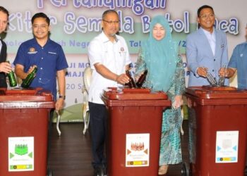 MISWAN YUNUS (tiga dari kiri) memasukkan botol kaca ke dalam tong sebagai gimik pelancaran Pertandingan Jom Kitar Semula Botol Kaca di Bangunan JOTIC, Johor Bahru.